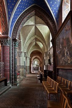 an empty church with wooden chairs and paintings on the walls