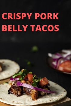 crispy pork and belly tacos on a cutting board with red onion garnish