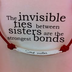 a red string bracelet with the words, the invisible ties between sisters are the strongest bonds