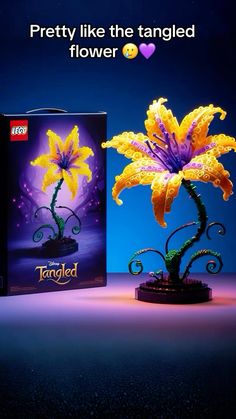 a purple and yellow flower is in front of a box with the words, pretty like the tangled flower