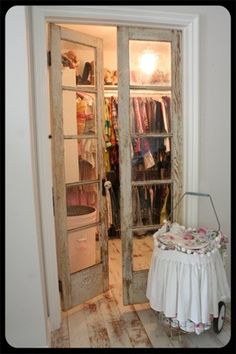 an open door leading to a closet with clothes on hangers