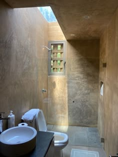 a bathroom with a sink, toilet and shower stall in the wall next to it