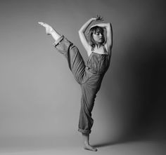 a woman in overalls doing a handstand