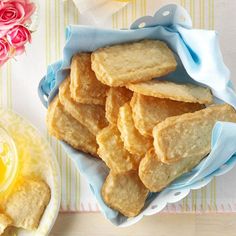 some cookies are in a bowl on a table next to a glass of orange juice