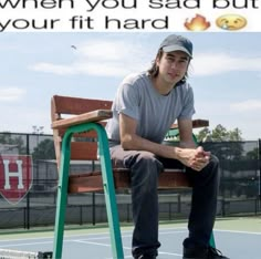 a man sitting on top of a wooden bench next to a tennis racquet