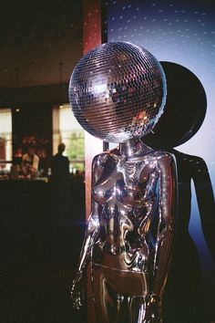 A mirror ball head Disco mannequin prop at a wedding reception room Disco Ball Hallway, Disco Ball Mannequin, Disco Party Inspiration, Disco Party Props, Disco Ball Sculpture, Dark Disco Aesthetic, Modern Disco Aesthetic, Disco Mannequin, Disco Architecture