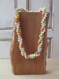 a wooden block with flowers on it sitting in front of a white door and a brown bag