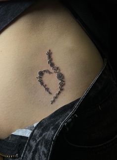 a woman's stomach with a small tattoo on the lower part of her belly