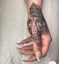 a woman's hand with an elephant tattoo on it and a flower in the middle