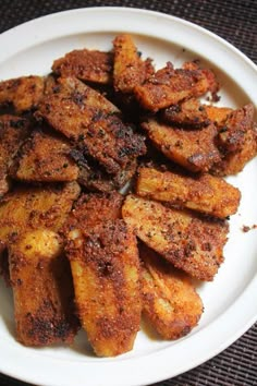 a white plate topped with fried bananas on top of a table