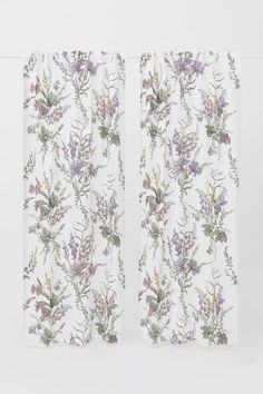 two white curtains with floral designs on them