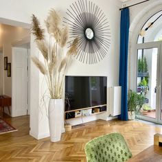 a living room filled with furniture and a flat screen tv on top of a wooden floor