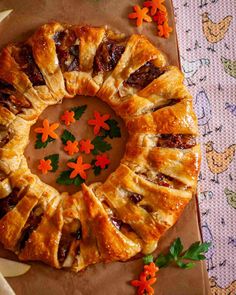 a pastry on a table with flowers and leaves around the edges that have been cut in half