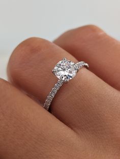 a woman's hand with a diamond ring on her left hand and the center stone is set in white gold