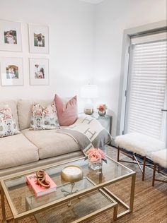 a living room filled with furniture and pictures hanging on the wall above glass coffee table