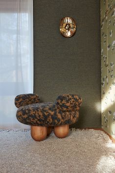 a chair sitting on top of a rug in front of a wall with a clock