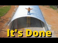 a man standing on top of a metal pipe in the middle of a dirt field