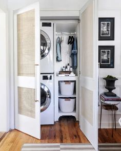 a washer and dryer in a room with wood floors, white walls and doors