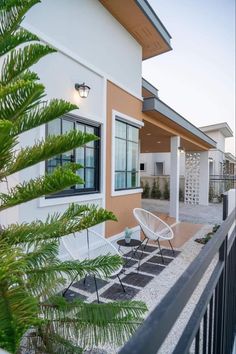 a white chair sitting on top of a patio next to a tree