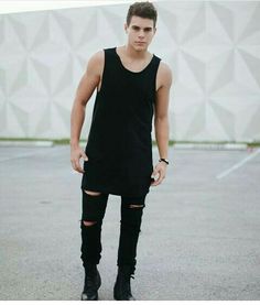 a young man standing in an empty parking lot