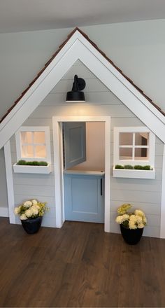 a doll house with flowers and plants in the window boxes on the front door area