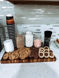 cookies, marshmallows and other snacks are arranged on a wooden cutting board