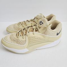 a pair of beige nike sneakers on a white background