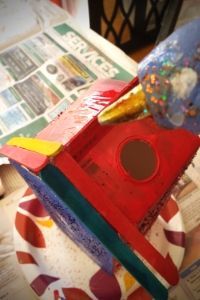 a birdhouse made out of magazines on a table