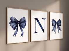 three framed art prints with blue bows on the front and back of each one, hanging on a wall