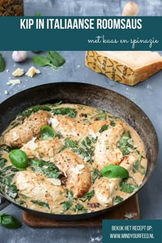 chicken and spinach stew in a skillet with garlic bread on the side next to it