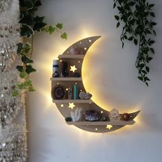 the moon shelf is lit up with stars and other things on it, along with greenery