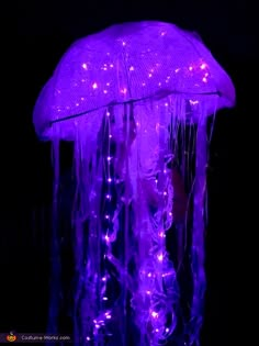 a purple jellyfish is glowing in the dark