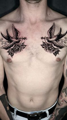 a man's chest with two birds and flowers on it, while he is wearing no shirt