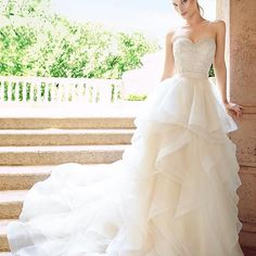 a woman in a wedding dress standing on some steps