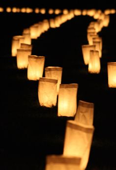 many paper lanterns are lit up in the dark