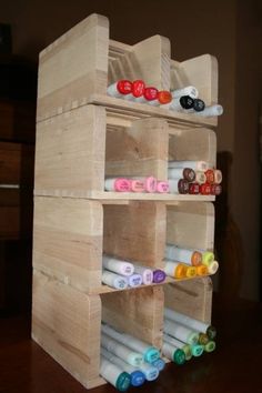 a wooden shelf with several different colored markers on it