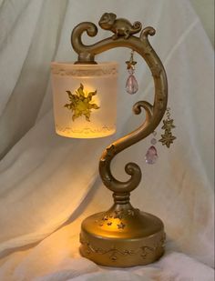 a lamp that is sitting on top of a white cloth covered tablecloth, with an ornate design