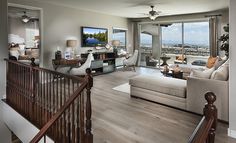 a living room filled with furniture and a flat screen tv on top of a wooden banister