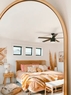 a bed room with a neatly made bed and a ceiling fan in the middle of it