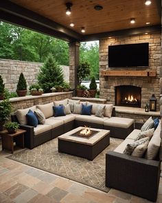 an outdoor living area with couches, tables and a fire place in the center