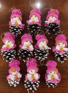 pine cones are decorated with pink and white dolls