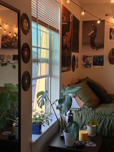 a bedroom with plants and pictures on the wall