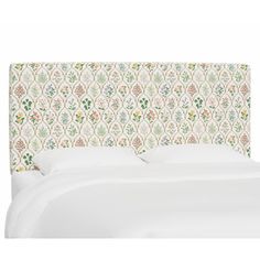 an upholstered headboard with flowers and leaves on the top, against a white background