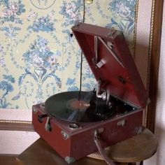 an old fashioned record player sitting on top of a wooden table next to a wall