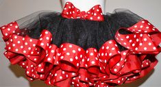 a red and black skirt with white polka dots on the bottom, attached to a mannequin