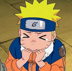 naruto sitting on the ground with his hands to his face