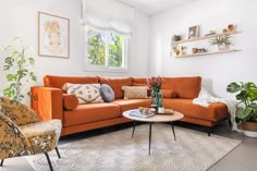 a living room with an orange couch and two chairs