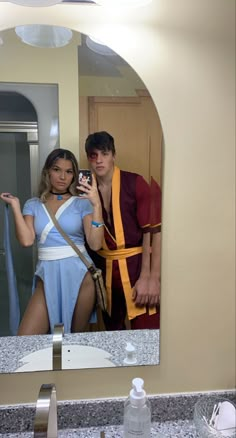 a man and woman are taking a selfie in the bathroom mirror while wearing costumes