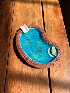 an empty swimming pool on a wooden table