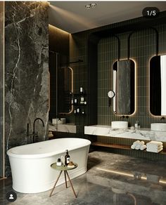 an elegant bathroom with marble walls and flooring is pictured in this image, there are two sinks on either side of the bathtub